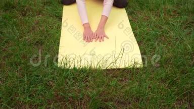 孕妇在公园的地毯上做瑜伽，做北极熊的姿势。